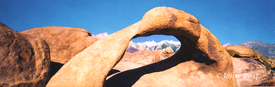 View thru arch  towards Mount Whitney and Sierra mountains, clear blue sky