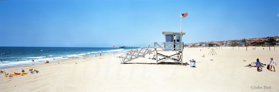 Lifeguard Tower on the beach flying an American flag two children and clear sky