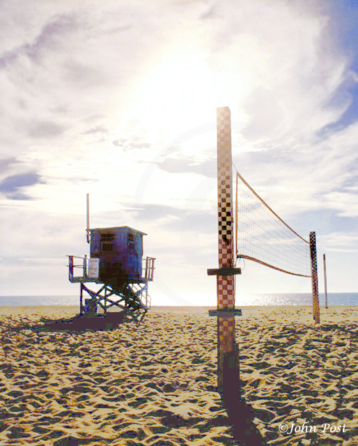 Lifeguard tower on beach, clear sunset sky with volleyball net and seagull on top of pole.