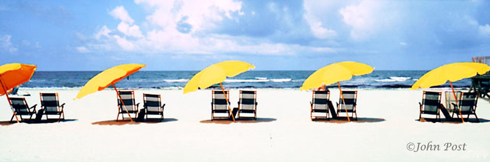 row of beach cahairs and brollys
