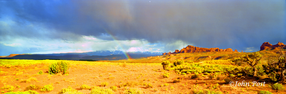 View down straight road leading into Great Sand Dunes National Park, Colo.Storm clouds in sky